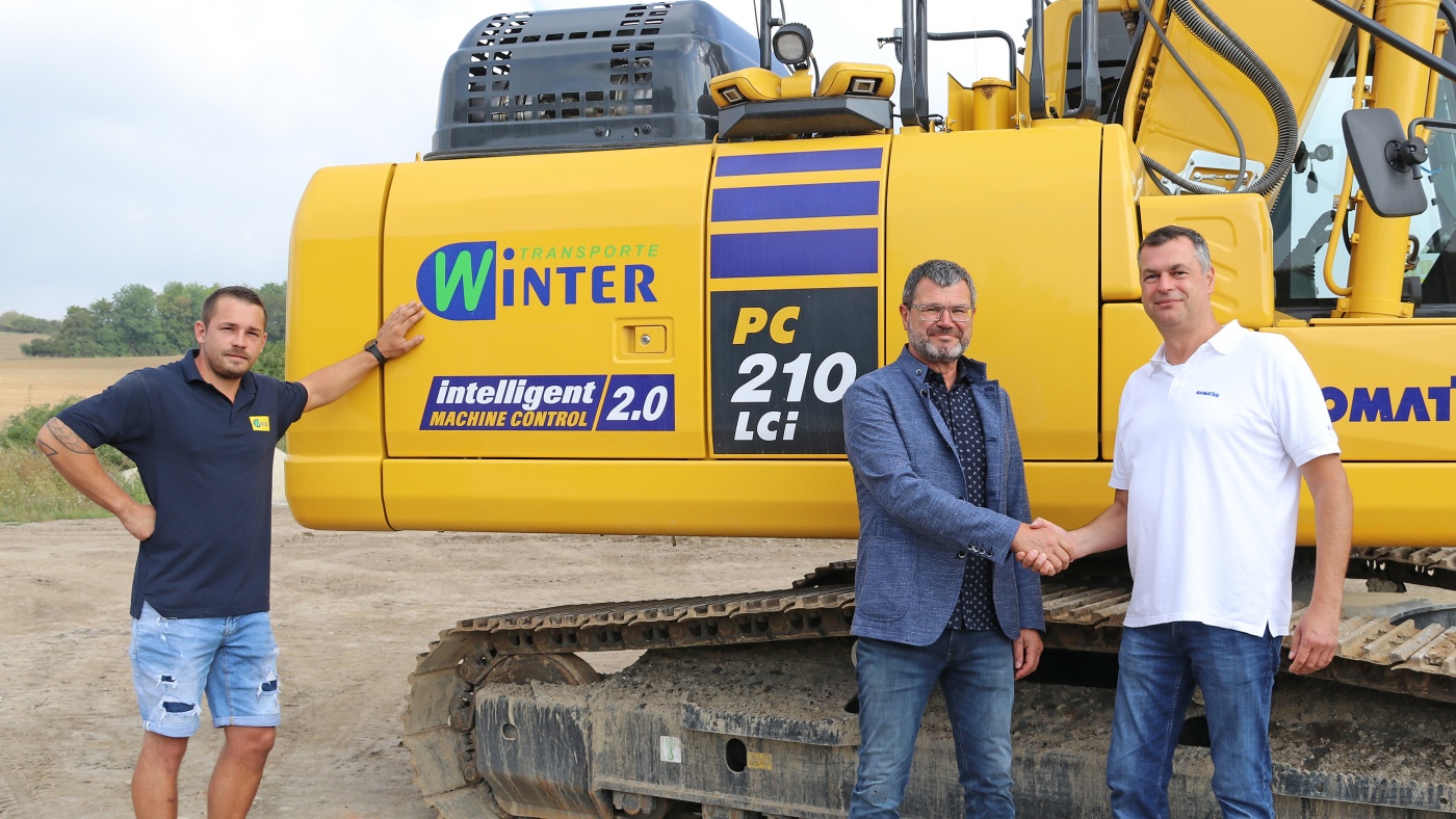 Slideshow Bild - Partnerschaft mit Handschlagqualität: Geschäftsführer Ing. Josef Winter (Winter Transporte Ges.m.b.H.; Mitte) mit Christian Schmidt (Verkauf, Kuhn Baumaschinen GmbH; rechts) und Maschinist Florian Strauß.
